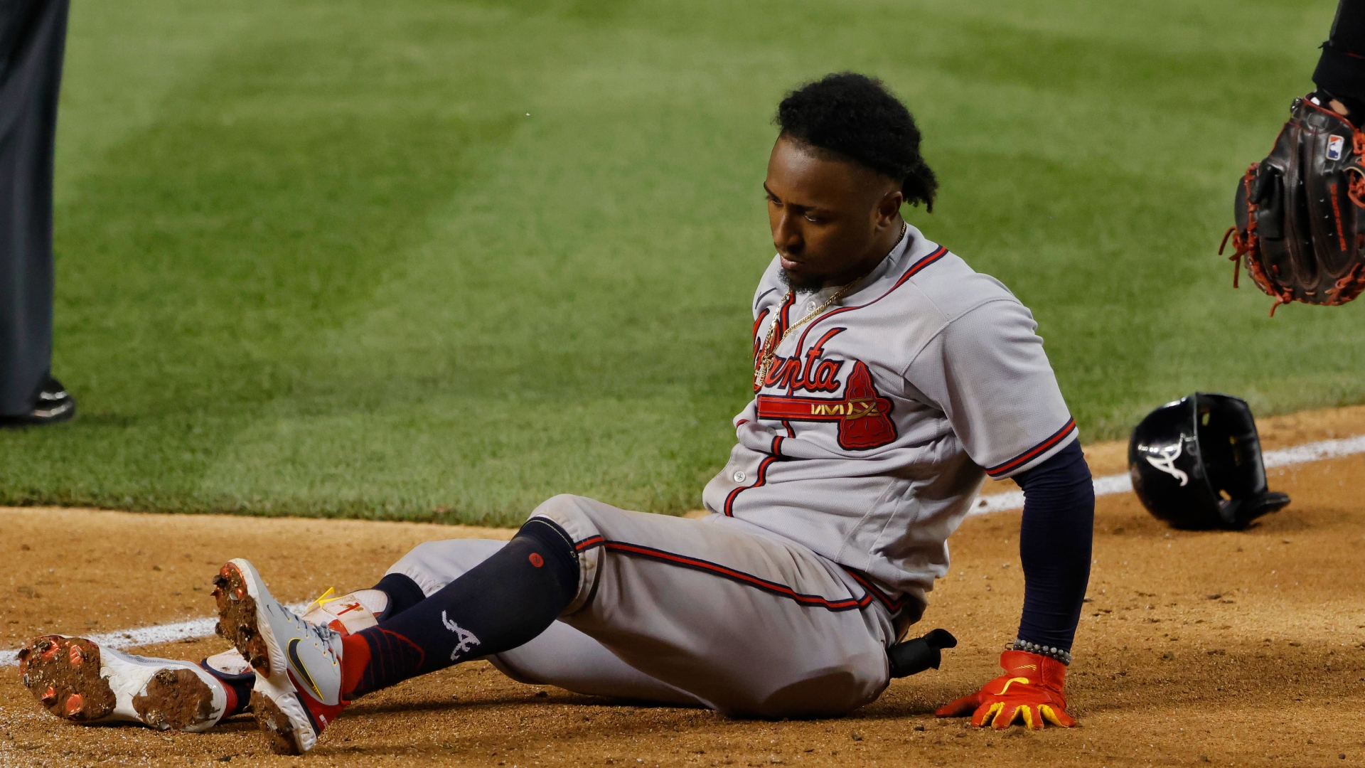 Ozzie Albies sits in the dirt after injuring his foot in a game against the Nationals
