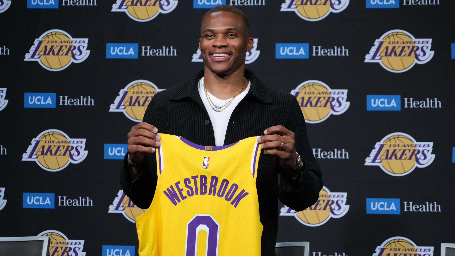 Russell Westbrook holds up his Lakers jersey during his introductory press conference